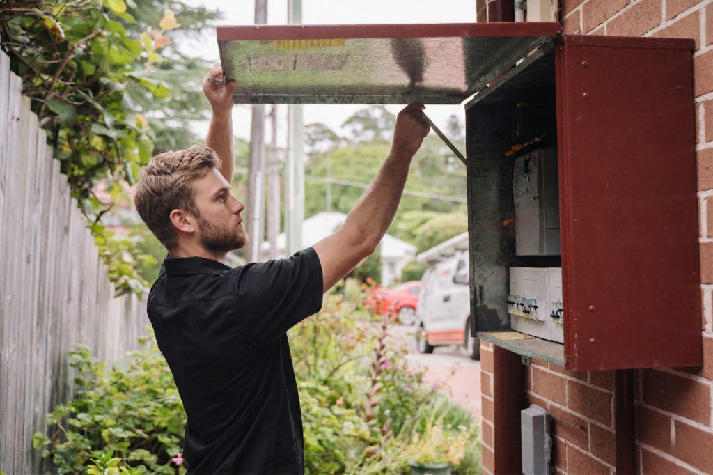 Electrician installing downlights in a Hurstville home
